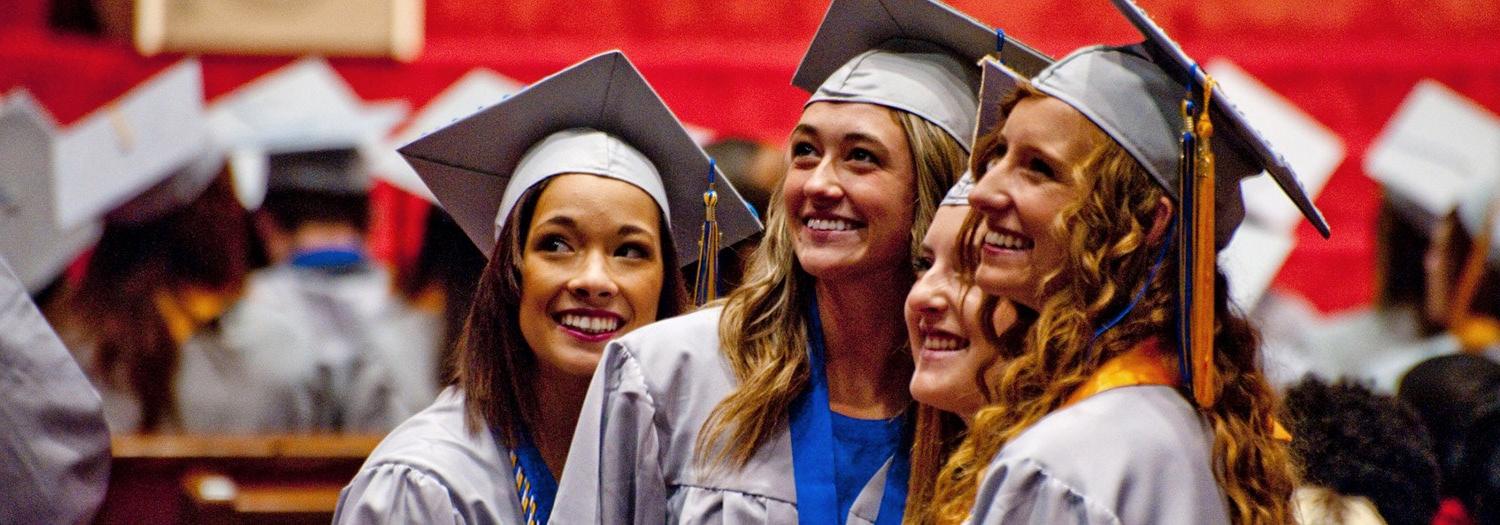 A group photo of happy graduates in their graduation attire.